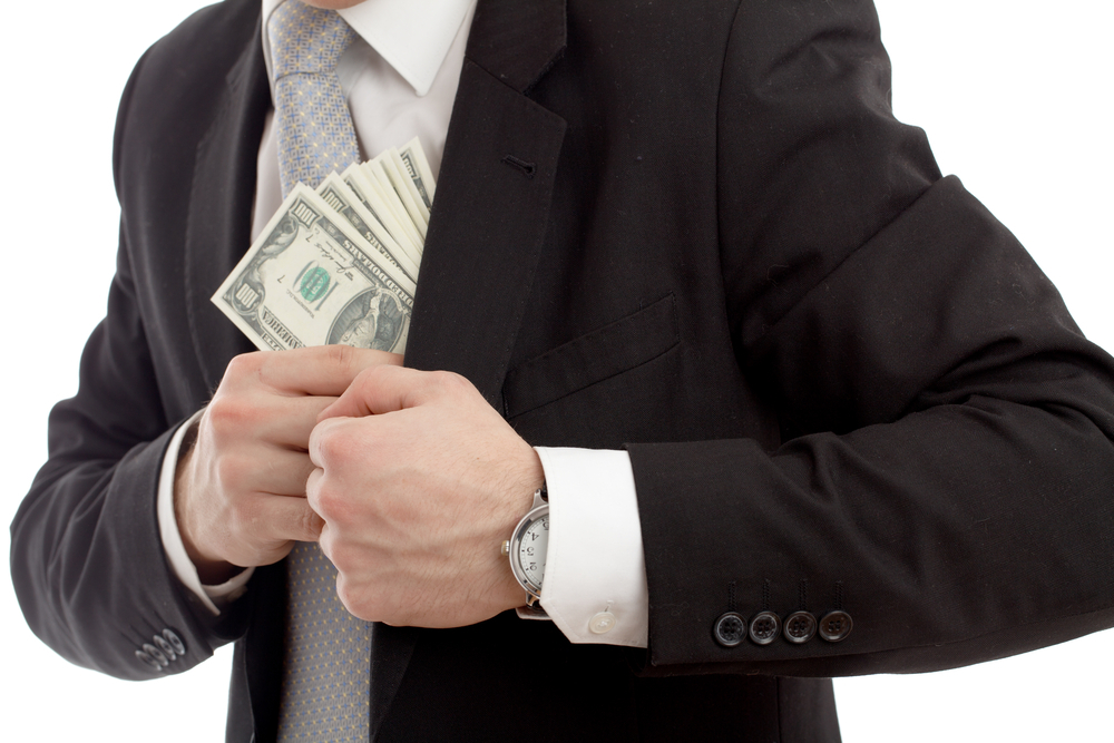 A businessman pocketing a wad of cash